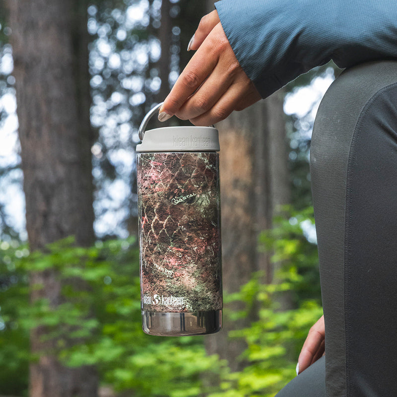 12oz-tkwide-with-cafe-cap-mossy-oak-u9 12oz_tumbler_mossyoak_rainbowtrout_hand_closeup_square.jpg